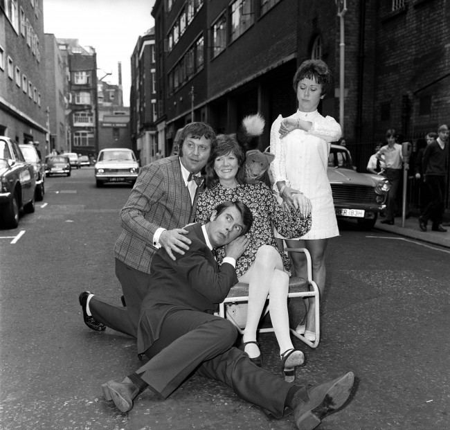 Leslie Crowther (second l) listens for the heart beat of Cilla Black's unborn child, assisted by Terry Scott (l), Basil Brush, who is looking over Cilla's shoulder, and Sheila Burnette, who is checking Cilla's pulse. Date: 06/07/1970