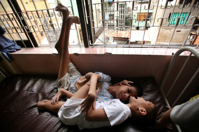 Trien Meng Hiep, 9, against wall, is hugged by another boy at a "Peace Village" center in Tu Du hospital in Ho Chi Minh City, Vietnam on Friday, May 25, 2007. Both of the boys were born with severe physical deformities typical of spina bifida and which hospital officials suspect to have been caused by their parents exposure to dioxin in the chemical defoliant Agent Orange. 