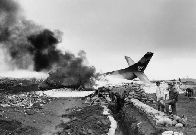 An American C-123 cargo plane burns after being hit by communist mortars while taxiing on marine post at Khe Sanh, South Vietnam on March 1, 1968. 
