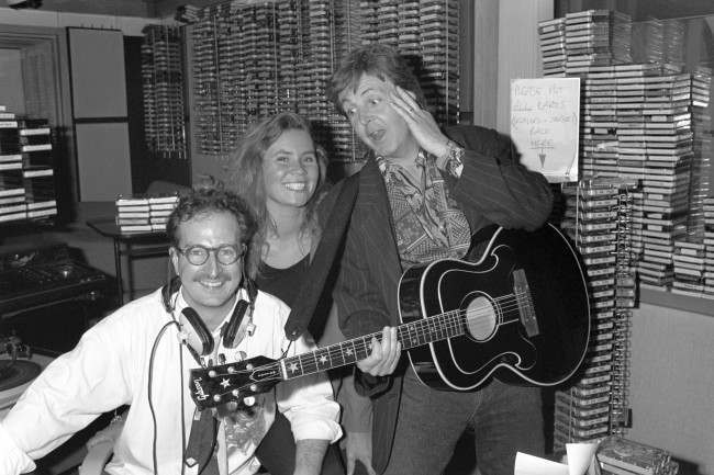 Paul McCartney surprising Radio 1 DJ Steve Wright and his production assistant Dianne Oxberry by dropping in for a chat after they broadcast an on-air appeal to meet him. Diane mentioned McCartney's name during a talk about the stars people would love to meet, and as he was working down the road on his new album, McCartney strolled into the studio and played live for Diane. Ref #: PA.8792508  Date: 13/06/1990 