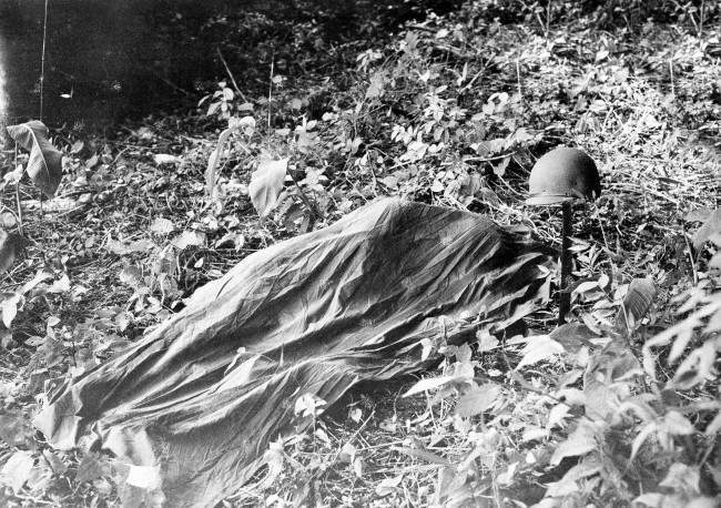 U.S. troops engaged in jungle maneuvers in Panama, August 5, 1942, have two methods of sleeping -- in a canopy-covered hammock (above) suspended from trees or on the ground (below) covered by cloth for protection against insects. Note rifle suspended from hammock. 