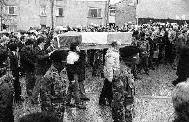 John Sands, (extreme left), puts his hands on his brother BobbyÂs coffin, as it is escorted by masked IRA men, from his parentÂs house to a church, in the Twinbrooks area of Belfast, Northern Ireland on May 6, 1981. The coffin will lie in the church overnight, until ThursdayÂs funeral ceremonies at BelfastÂs Milltown cemetery. (AP Photo/Peter Kemp)