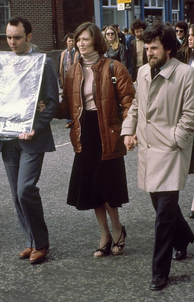 Marcela Sands, sister of Bobby Sands M.P., hunger-striking inmate of the Maze Prison, walks hand in hand with his election agent Owen Crow during a protest rally in Northern Ireland in April 1981. (AP Photo/Peter Kemp) Date: 01/04/1981