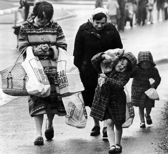 An unidentified Catholic family struggles home, loaded down with provisions, after a shopping expedition in Belfast on Thursday, April 30, 1981. Homes in Belfast have been collecting supplies recently in case of major civil disorders following the expected death of IRA hunger striker Bobby Sands. (AP Photo/Peter Kemp)