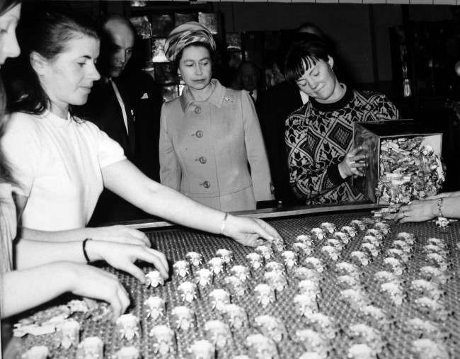 *Scanned low-res from print, high-res available on request* Queen Elizabeth II watches as miniature models are spread on a conveyor belt during her visit to the makers of the "Matchbox" models series - Lesney Products and Company Ltd - at Hackney Wick, London. Ref #: PA.13433485  Date: 12/11/1969