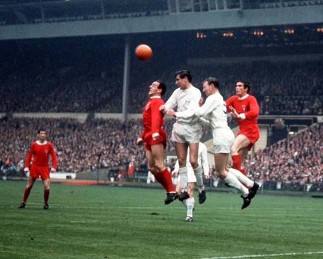 Liverpool players Ian St John (left, red shirt) and Ron Yeats (right), battle for the ball with Leeds United players Norman Hunter (2nd left, white shirt) and Jack Charlton (2nd right),