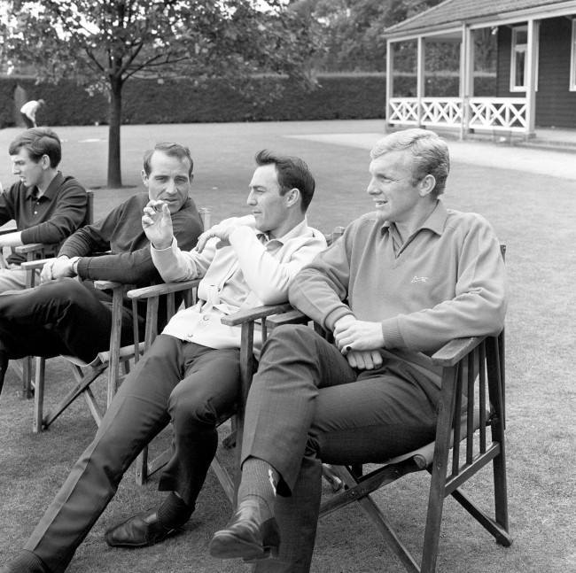 It can't be a fishing story, it might be the size of the hole in his injured leg. But whatever it is, Jimmy Greaves holds the attention of fellow England World Cup squad players Bobby Moore (right) and Ron Springett as they relax at Roehampton, London. Date: 29/07/1966