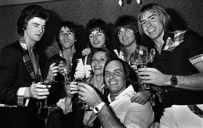 The Bay City Rollers, currently on a concert tour of Britain, celebrate with champagne at a Manchester hotel after the announcement that their 36-year-old manager, Tam Paton (centre) has become engaged to Czech-born 28-year-old London art student Marcella Knaiflova. PA/PA Archive/Press Association Images
