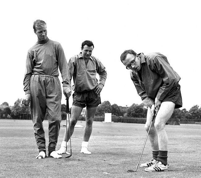 Nobby Stiles, the Manchester United wing-half, concentrates hard during a putting session at the Bank of England Sports Club ground, Roehampton, London, where he was training with other members of England's World Cup squad. Watching him are Leeds United half-back Jackie Charlton (left) and Blackpool full-back Jimmy Armfield. 