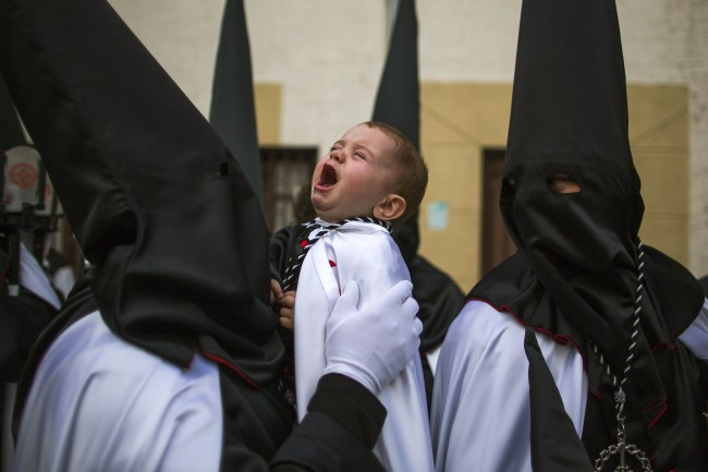 A child cries as penitents from 'Jesus en su Tercera CaÃ­da' brotherhood take part in a procession in Zamora, Spain, 