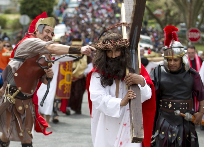 Jesus Christ, center, portrayed by Rodrigo Campos, reenacts the Passion of Christ with other parishioners of San Bernard Catholic Church, through the streets of Riverdale Md., during a Good Friday procession to commemorate the Stations of the Cross on Friday, April 18, 2014. 