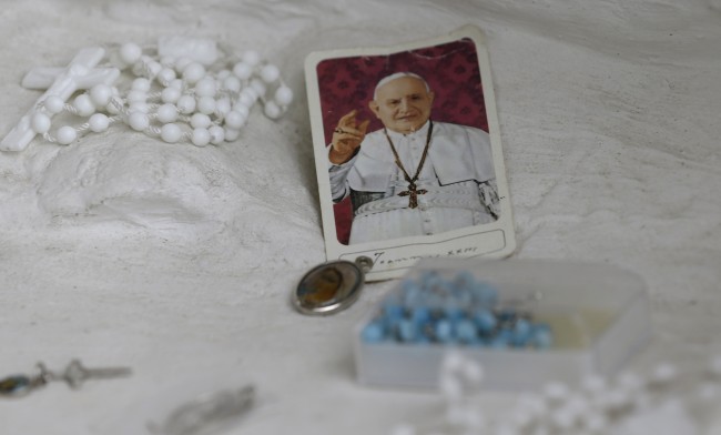Memorial items of the Pope John XXIII are laid on the foot of Pope John XXIII statue at the parish church in Sotto il Monte Giovanni XXIII, northern Ital