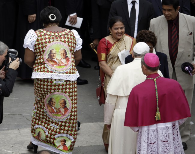 A guest wears a dress portraying Pope John Paul II and Pope John XXIII as she leaves after greeting Pope Francis