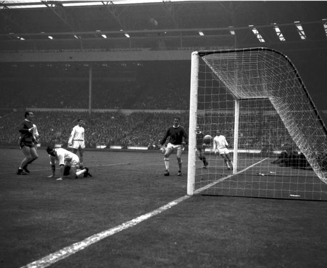 Leeds goalkeeper Sprake watches, helpless, as the ball shoots into the net to notch Liverpool's first goal, in the FA Cup Final at Wembley. Looking on is Liverpool centre forward Ian St. John (left). Others are left to right, Bell and Hunter of Leeds, Byrne (Liverpool) and Reaney (Leeds). Liverpool won 2-1, all the goals being scored in extra time. 