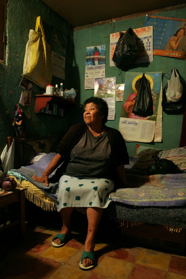 A sixty-five year old prostitute who identifies herself as "La Abuelita," or "The Grandmother," poses for a portrait in a rented room where she has been living for the last 42 years 