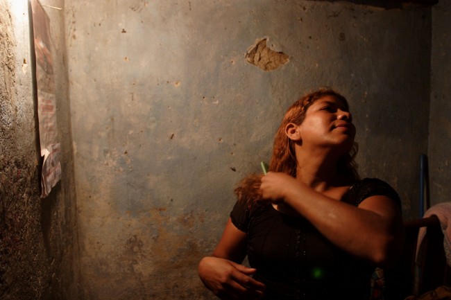 A prostitute from Nicaragua who identifies herself as Mari brushes her hair while waiting for clients