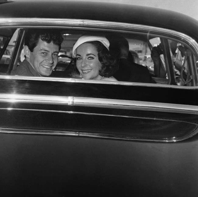 Liz Taylor and Eddie Fisher flash happy smiles through the window of their auto on May 12, 1959 in Las Vegas, as they were driven off from the county courthouse where Fisher first divorced Debbie Reynolds and then obtained a license to marry Miss Taylor. The wedding was to take place a couple of hours later in a Jewish synagogue. (AP Photo) Ref #: PA.7334972  