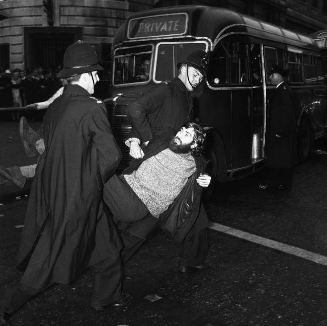 A long-haired young man, wearing a beard and beatnik style clothes, is carried to a waiting van by police after being arrested during the huge Ban-the-bomb rally in LondonÂs Trafalgar Square, United Kingdom on Sept. 17, 1961. Many arrests were made during skirmishes between police and demonstrators as the crowd grew to well over 10,000. Hundreds of extra police were called on duty to deal with the crowds.