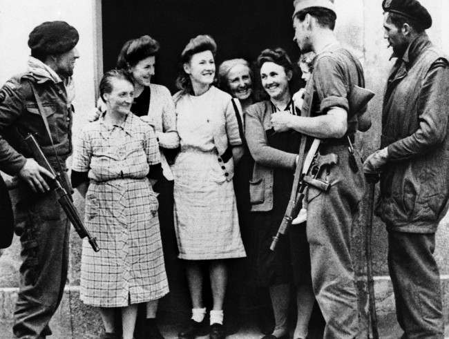 Villagers of Amfreville, France, chat with members of a French commando unit who landed in Normandy with Allied forces on June 20, 1944. (AP Photo)