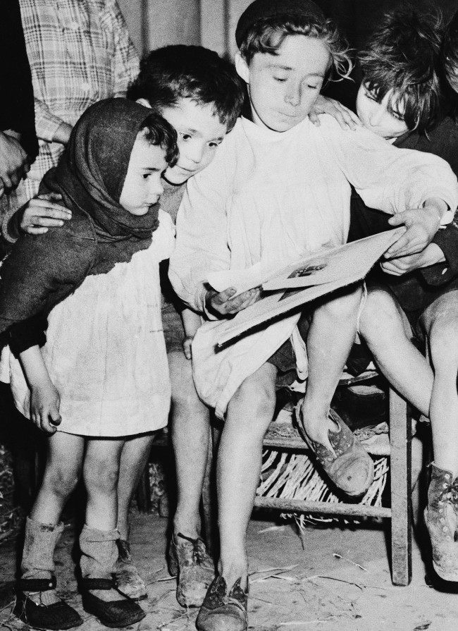 While the battle raged around them during the allied push in Normandy last summer, these French children found refuge in the Cathedral in Caen. Most of them were stocking less, their shoes were torn, their garments shoddy. Children caught in the holocaust of war in Caen on May 18, 1945. (AP Photo)
