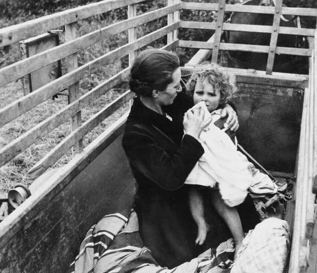 Arriving behind the allied lines in Normandy via the family horse-drawn wagon, French mother and child take advantage of their first few moments of safety to spruce up a bit on July 14, 1944. (AP Photo) 