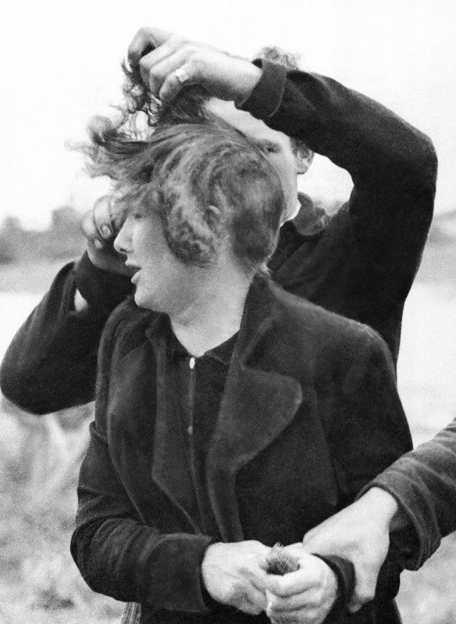 Grande Guillotte, 23 year-old-French girl collaborated with the Germans in Normandy. When her town was liberated by Allied troops, French patriots dragged her from her house and cut off all her hair. A French patriot cuts off Grande GuillotteÂs hair while another holds her in France on July 7, 1944. (AP Photo) 