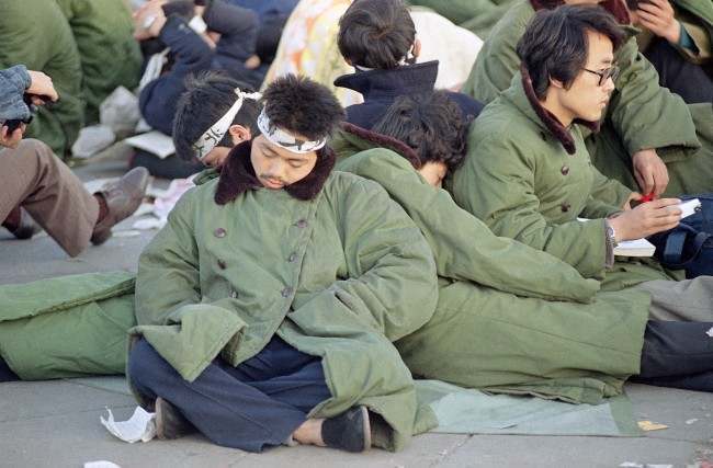 Student protesters in Beijing's Tiananmen Square sleep leaning on one another at sunrise, Sunday, May 14, 1989 in Beijing. The protesters, some of them on a hunger strike, plan to remain in the square for the official welcoming ceremony for Soviet leader Mikhail Gorbachev on Monday. (AP Photo/Mark Avery) 