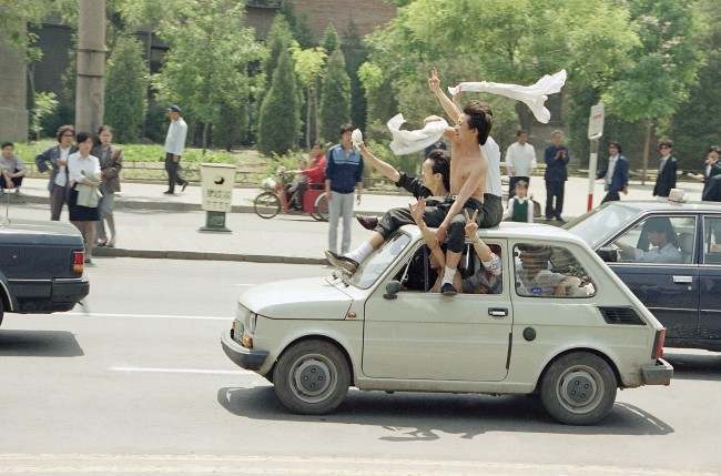 Beijing youths ride atop a car as they parade to Tiananmen Square for a freedom rally, Wednesday, May 17, 1989 in Beijing. (AP Photo/Sadayuki Mikami)