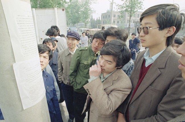 Beijing residents read a copy of a newspaper printed by students and placed on a streetlight pole near the Beijing University campus describing the student demonstrations on Friday and Saturday at Tiananmen Square, April 24, 1989. The student paper, placed on trees and light-posts around the city is an attempt to counter a government imposed news black-out of student demonstrations. (AP Photo/Mark Avery)