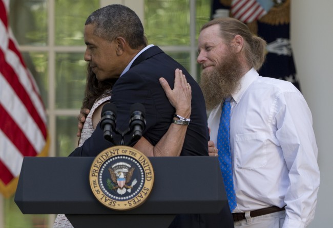 President Barack Obama hugs Jani Bergdahl, as Bob Bergdahl, stands at right, during a news conference in the Rose Garden of the White House in Washington, Saturday, May 31, 2014 about the release of their son, U.S. Army Sgt. Bowe Bergdahl, from captivity. Bergdahl, 28, had been held prisoner by the Taliban since June 30, 2009. He was handed over to U.S. special forces by the Taliban in exchange for the release of five Afghan detainees held by the United States. (AP Photo/Carolyn Kaster)