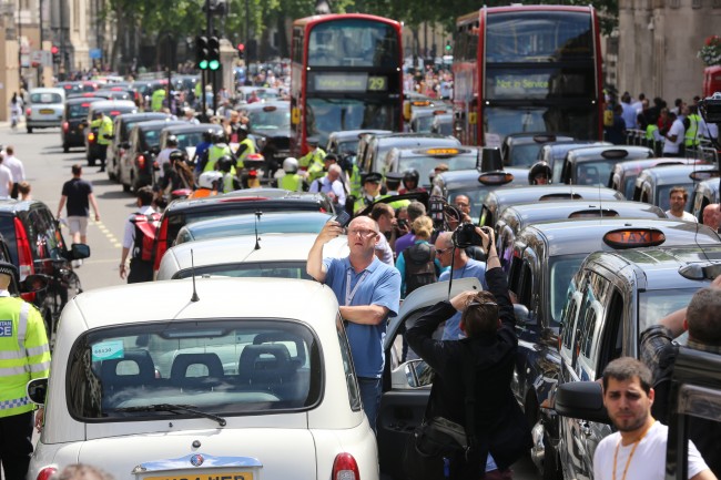 Black cab and licensed taxi drivers protest at Trafalgar Square, London over the introduction of a phone app called Uber which allows customers to book and track vehicles.