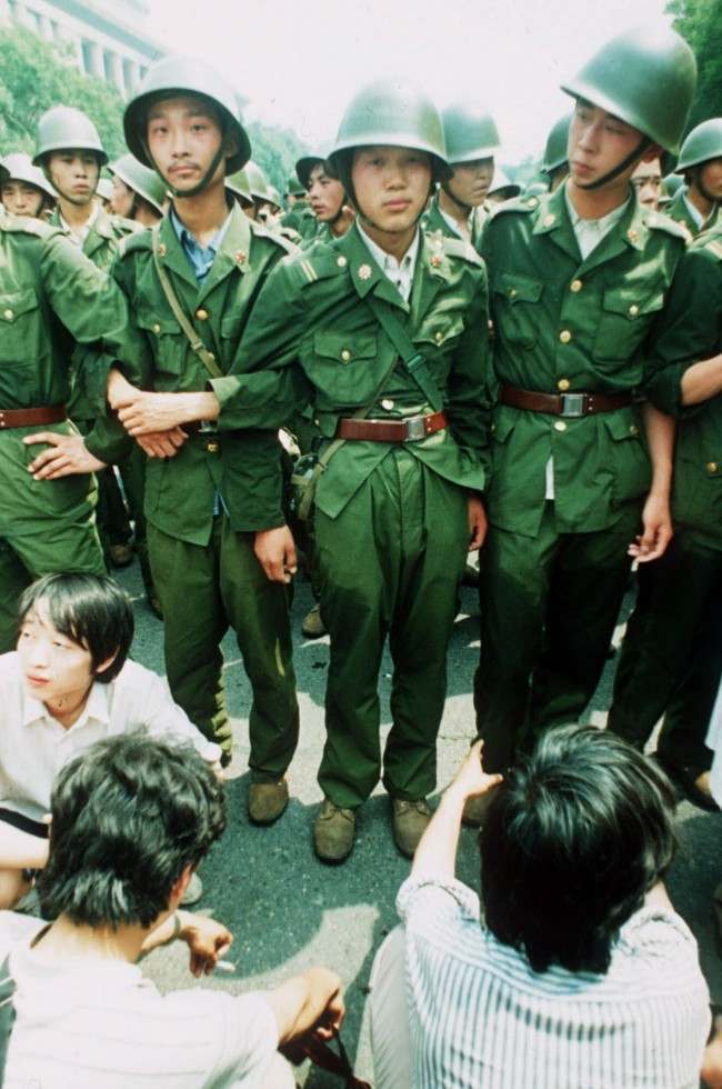 PLA soldiers locked in arms try to march past a human blockade of students outside of the Great Hall of People in this June 3, 1989 photo. Soldiers were reported to resort to teargas and amunitions. On Friday, it will be 10 years since the military assault that killed hundreds and ended seven weeks of protests centered on Tiananmen Square. (AP Photo/Liu Heung Shing)
