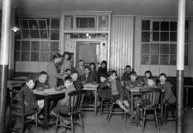 London Scene - Children's Homes - 1931 Canning Town, poor children having soup.