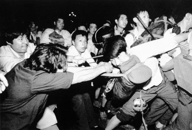 A man tries to pull a Chinese soldier away from his comrades as thousands of Beijing's citizens turned out to block thousands of troops on their way towards Tiananmen Square early Saturday morning, June 3, 1989. (AP Photo/Mark Avery)