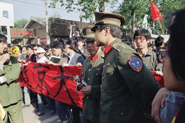 Chinese police try in vain to convince students from Beijing University not to march as they emerged from their campus on Thursday, April 27, 1989 in Beijing. The students from several Beijing universities began a planned march to Tiananmen Square on Thursday in defiance of a government demand they end their campaign for political reform. (AP Photo/Mark Avery)