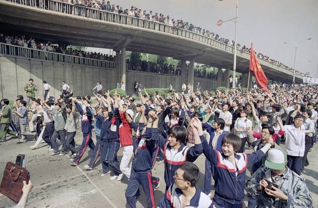 Students of Teachers University raise their hands to appeal to supporting citizens near Tiananmen Square, Thursday, May 4, 1989 in Beijing. (AP Photo/Sadayuki Mikami)