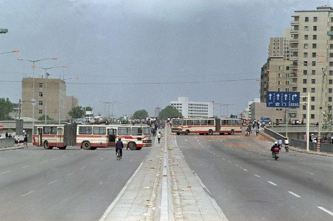 A convey of soldiers from the Peoples' Liberation Army is completely engulfed by demonstrators who stopped the Tiananmen Square bound troops by blocking the road with the bus in the foreground, May 21, 1989, Beijing, China. (AP Photo/Jim Palmer)