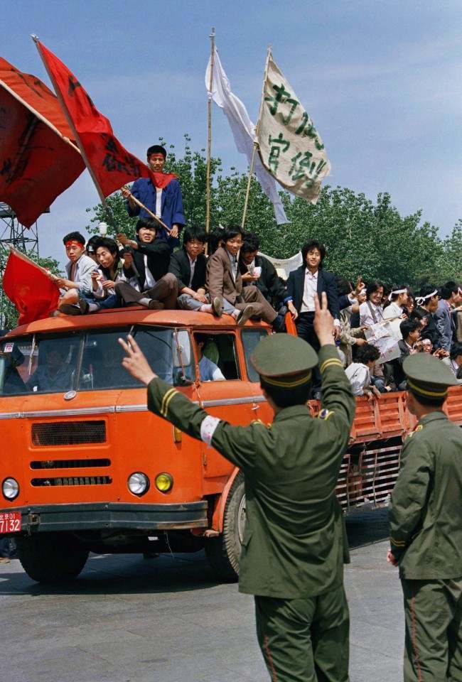 A Beijing policeman encourages university students demonstrating for democratic reforms on Friday, May 19, 1989 in Beijing's Tiananmen Square. (AP Photo/Sadayuki Mikami)