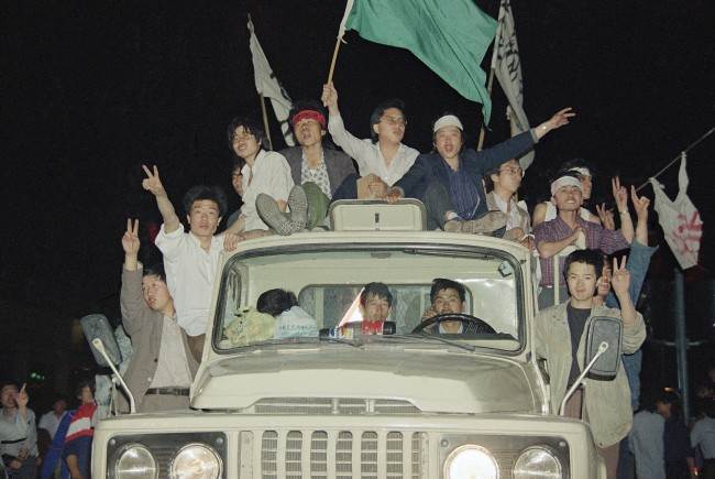 Unidentified demonstrators showing victory signs head to Tiananmen Square, Saturday, May 20, 1989, Beijing, China. (AP Photo/Sadayuki Mikami)