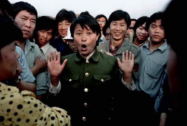 A woman soldier sings among pro-democracy protesters occupying Beijing's Tiananmen Square, about June 2, 1989. Police and military would occasionally mix with protesters in an attempt to keep the demonstration peaceful. In the early morning hours of June 4, 1989, soldiers overran the square, leaving hundreds dead overnight. (AP Photo/Jeff Widener)