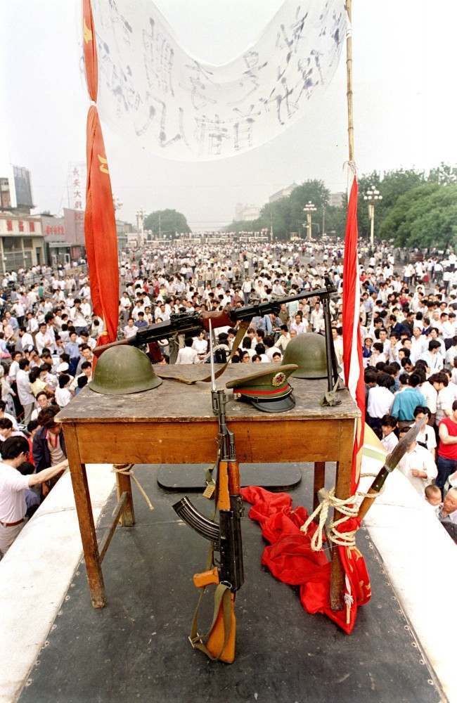 Chinese military items, including rifles, helmets, and a hat, are displayed during the pro-democracy demonstration that lasted from mid-April to early June 1989 on Beijing's Tiananmen Square. The demonstration ended with a government crackdown on June 4, 1989, leaving hundreds dead. (AP Photo/Jeff Widener)