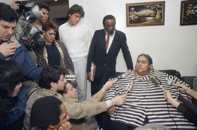 Eight-hundred-pound Walter Hudson explains that he couldn't muster the courage to leave the home he hasn't been out of for 18 years, Feb. 5, 1988 in Hempstead, New York. Hudson, 42, weighed 1,200 pounds a few months ago before going on a diet supervised by Dick Gregory, who stands beside him during the interview. (AP Photo/David Bookstaver)