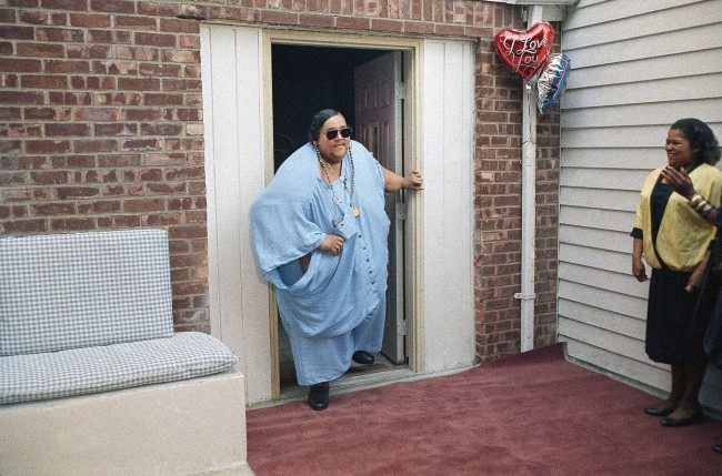 Walter Hudson, who had not walked out of his Hempstead, New York, home for 18 years, takes his first steps outdoors, Sept. 8, 1988. Hudson, who weighed 1,200 to 1,400 pounds, announced he is down to 520 pounds. (AP Photo/Charles Wenzelberg)
