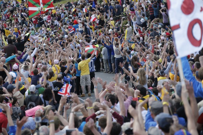 Spectators line the road on Bradfield pass as they wait for the pack during the second stage of the Tour de France cycling race over 201 kilometers (124.9 miles) with start in York and finish in Sheffield, England, Sunday, July 6, 2014. (AP Photo/Christophe Ena)