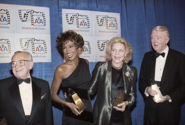 From left, Columbia Pictures chairman Leo Jaffe, Whitney Houston, Lauren Bacall and Jimmy Stewart receive awards at the Eighth American Cinema Awards in Beverly Hills, Calif., Jan. 12, 1991. The American Cinema Foundation supplies educational scholarships in theater arts, music and dance. (AP Photo/Craig Fujii)