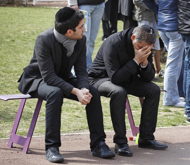 A man is overcome by emotion during a ceremony for the shooting victims at the Ozar Hatorah Jewish school where a gunman opened fire Monday killing four people in Toulouse, southwestern France, Tuesday, March 20, 2012. Police blanketed southern France on Tuesday, searching for a gunman _ possibly a racist, anti-Semitic serial killer _ who killed four people at a Jewish school and may have filmed his attack.(AP Photo/Remy de la Mauviniere)