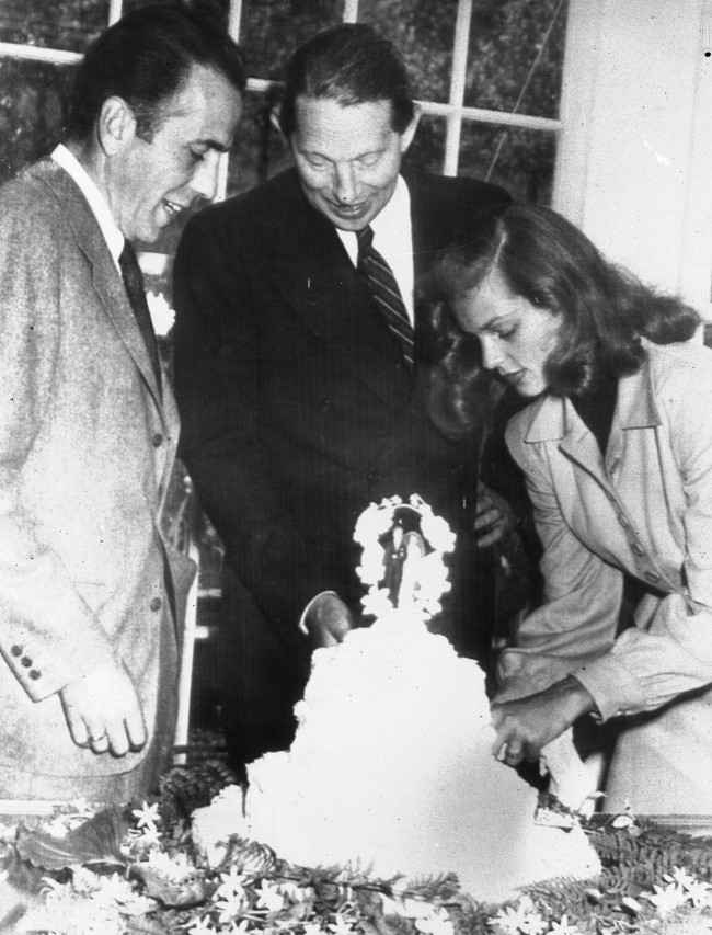  In this May 21, 1945 file photo, novelist Louis Bromfield, center, helps actor Humphrey Bogart and his bride, actress Lauren Bacall, cut the cake after their wedding at Bromfield's Malabar Farm near Lucas, Ohio.