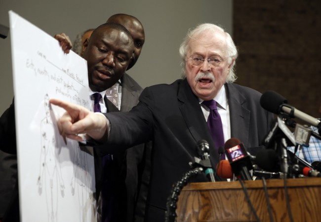 Dr. Michael Baden, right, speaks as Brown family attorney Benjamin Crump, left, holds a diagram produced during a second autopsy done on 18-year-old Michael Brown Monday, Aug. 18, 2014, in St. Louis County, Mo. The independent autopsy shows Brown was shot at least six times. (AP Photo/Jeff Roberson)