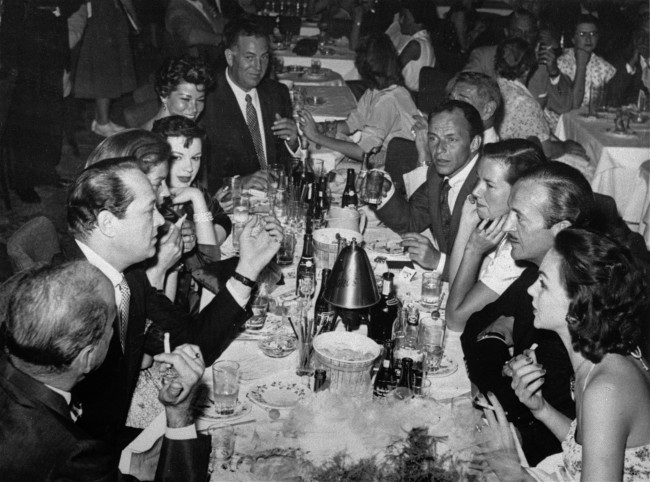 Some members of the Holmby Hills Rat Pack, a group of exceedingly well heeled Bohemians that include screen stars and millionaires from Hollywood's super-ritzy Holmby Hill section, are seen sitting at a table having cocktails at the Copa Room in Hollywood, Oct. 15, 1956.. Shown left to right are Humphrey Bogart; producer Sid Luft; Lauren Bacall; Judy Garland; Ellie Graham; agent Jack Entratter; restaurateur Mike Romanoff (partly hidden); Frank Sinatra; Mrs. Romanoff; actor David Niven; and Mrs. Niven. (AP Photo)