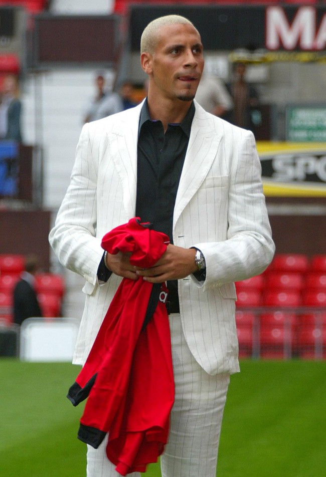 Manchester United's new 30 million signing Rio Ferdinand holds a shirt as he walks across the pitch at the club's Old Trafford ground. The 23-year-old former Leeds defender smashed British transfer fee records when he moved across the Pennines to become the sixth most expensive footballer of all time.  Date: 22/07/2002